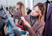 Mulher numa loja a verificar etiquetas de roupa para comparar preços.